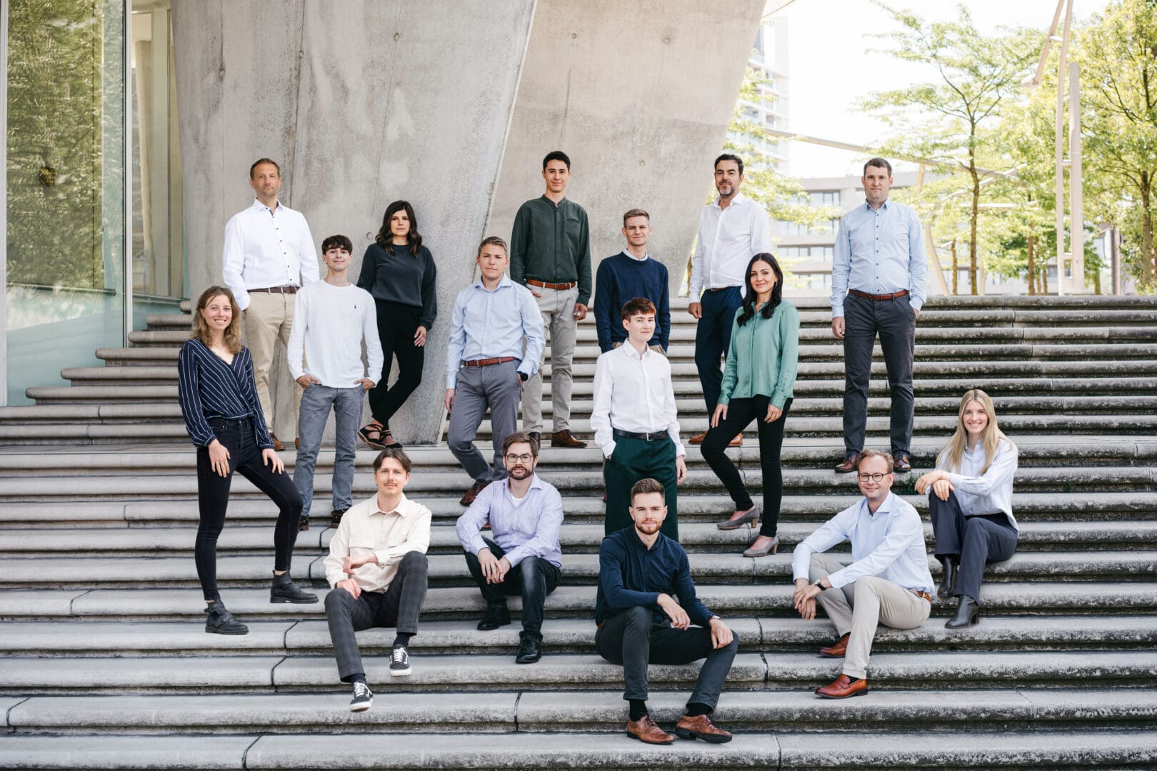 Teambild des Unternehmens mit allen Mitarbeitern auf einer Treppe